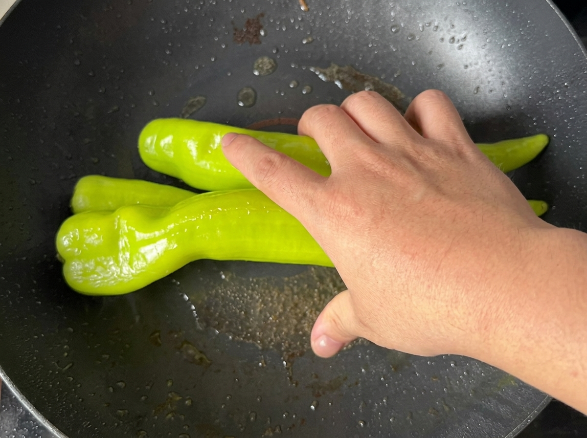 Poivrons verts grillés à la poêle jusquà ce que la peau soit cloquée.