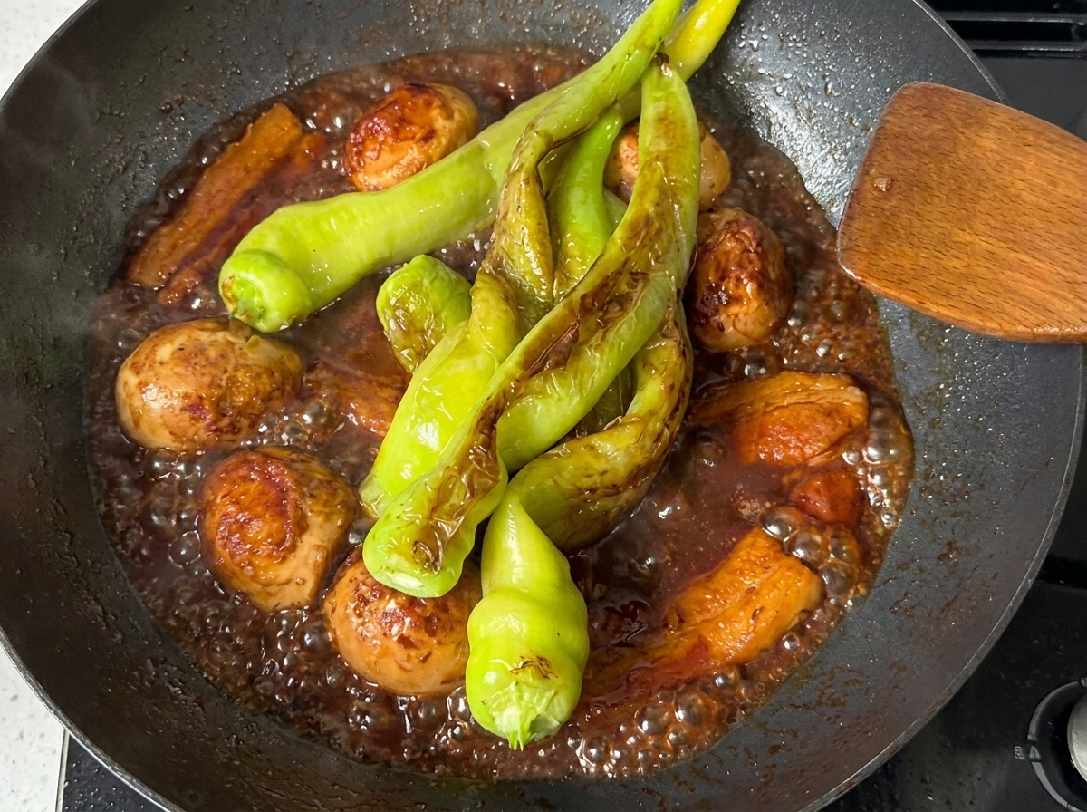 Poivrons mijotant dans la sauce sombre et riche avec le porc et les œufs.