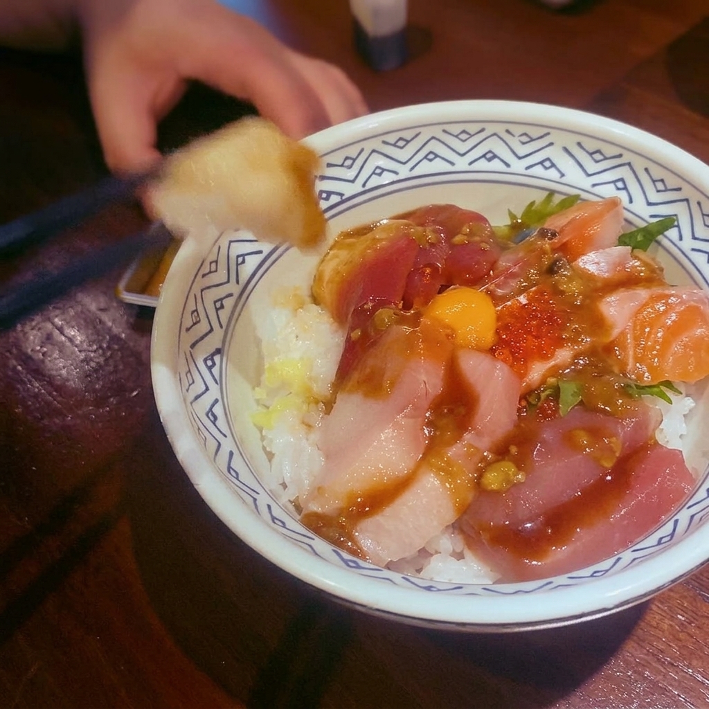 Bol de sauce au curry rouge servi sur une protéine et garni de feuilles de combava.
