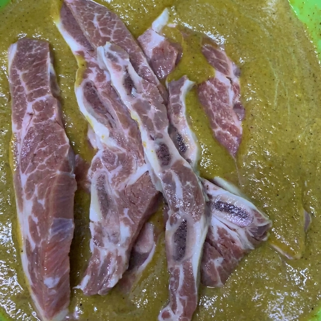 Travers de bœuf en cours de mélange dans un bol rempli de marinade.