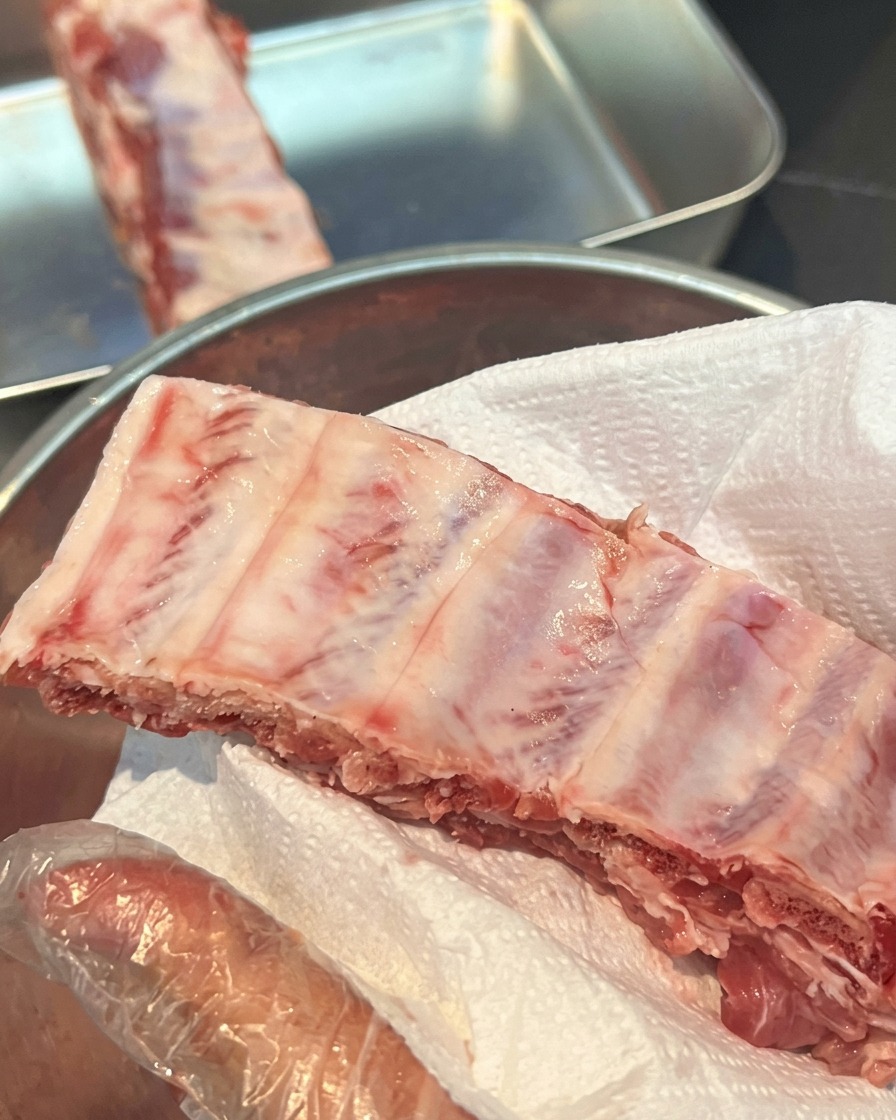 Travers de porc crus posés sur un essuie-tout blanc pour absorber lhumidité.