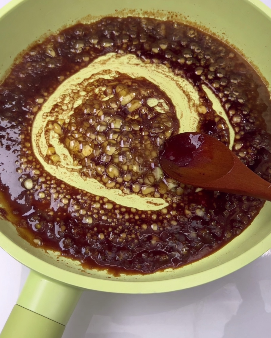 Travers de porc cuits enrobés dune sauce riche dans une poêle.