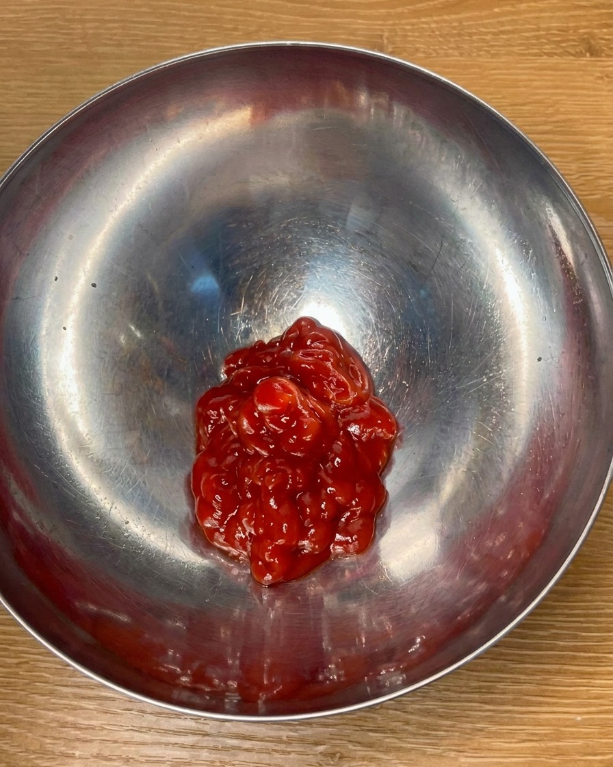 Ketchup et assaisonnements mélangés dans un bol pour créer une sauce savoureuse.