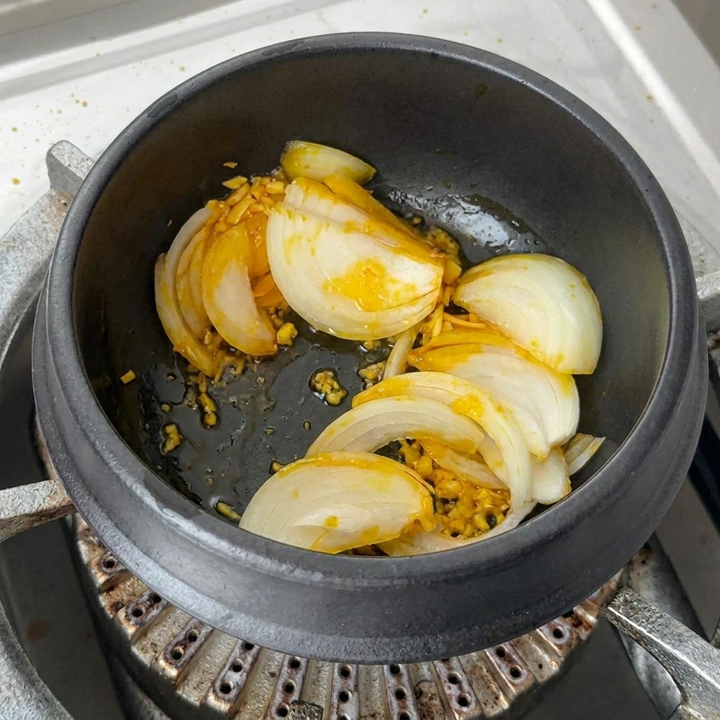 De généreuses portions de kimchi haché et de tranches de piment rouge mélangées dans le pot.