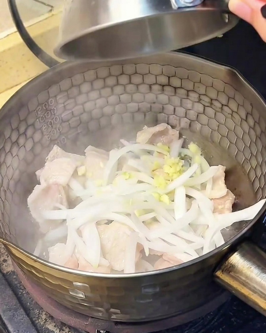 Tranches doignon et ail haché ajoutés dans la casserole avec le porc cuit.