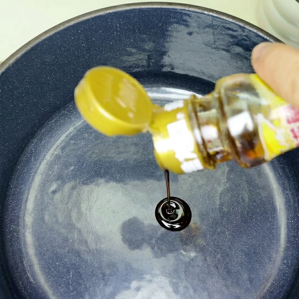 Des morceaux de poitrine de porc et doignons émincés qui grésillent dans une poêle chaude.