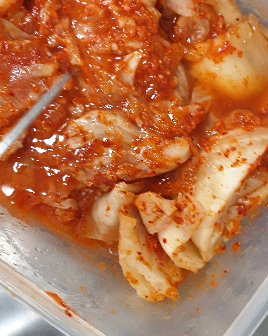 Utilisation dune pince pour déposer du kimchi fermenté dans la marmite bouillonnante.