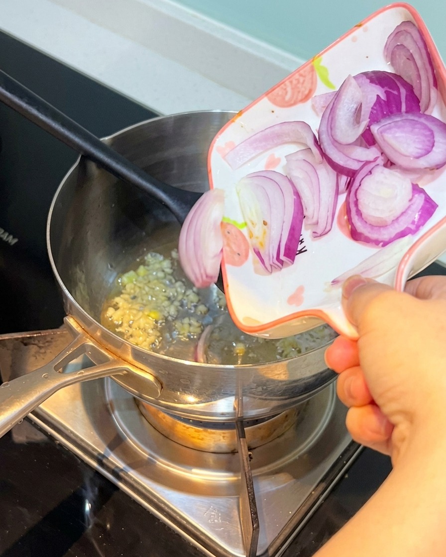 Oignon rouge émincé ajouté dans la casserole avec lail.