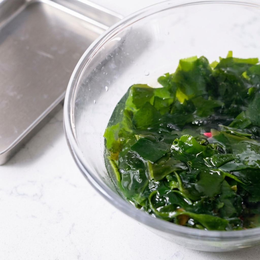 Wakame réhydraté récupéré avec une cuillère à trous.