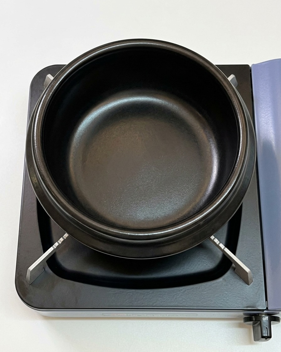Huile de sésame au fond dun pot en terre cuite noir sur une cuisinière.