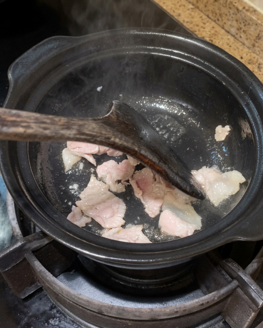 Oignon et ail sautés dans la marmite avec le porc.