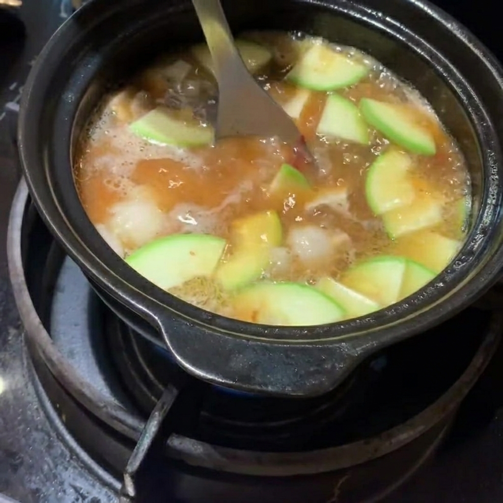 Courgette tranchée et pommes de terre en dés ajoutées au ragoût.