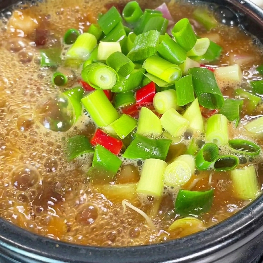 Gros plan sur le ragoût de pâte de soja mijotant, assaisonné avec de la poudre de piment rouge et de la poudre de bœuf.