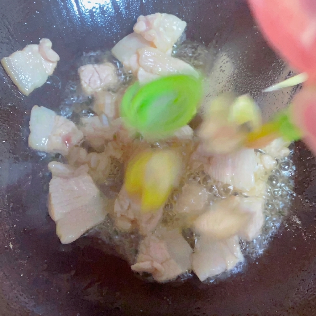 Oignons verts, gingembre et ail sautés avec du porc dans un wok.