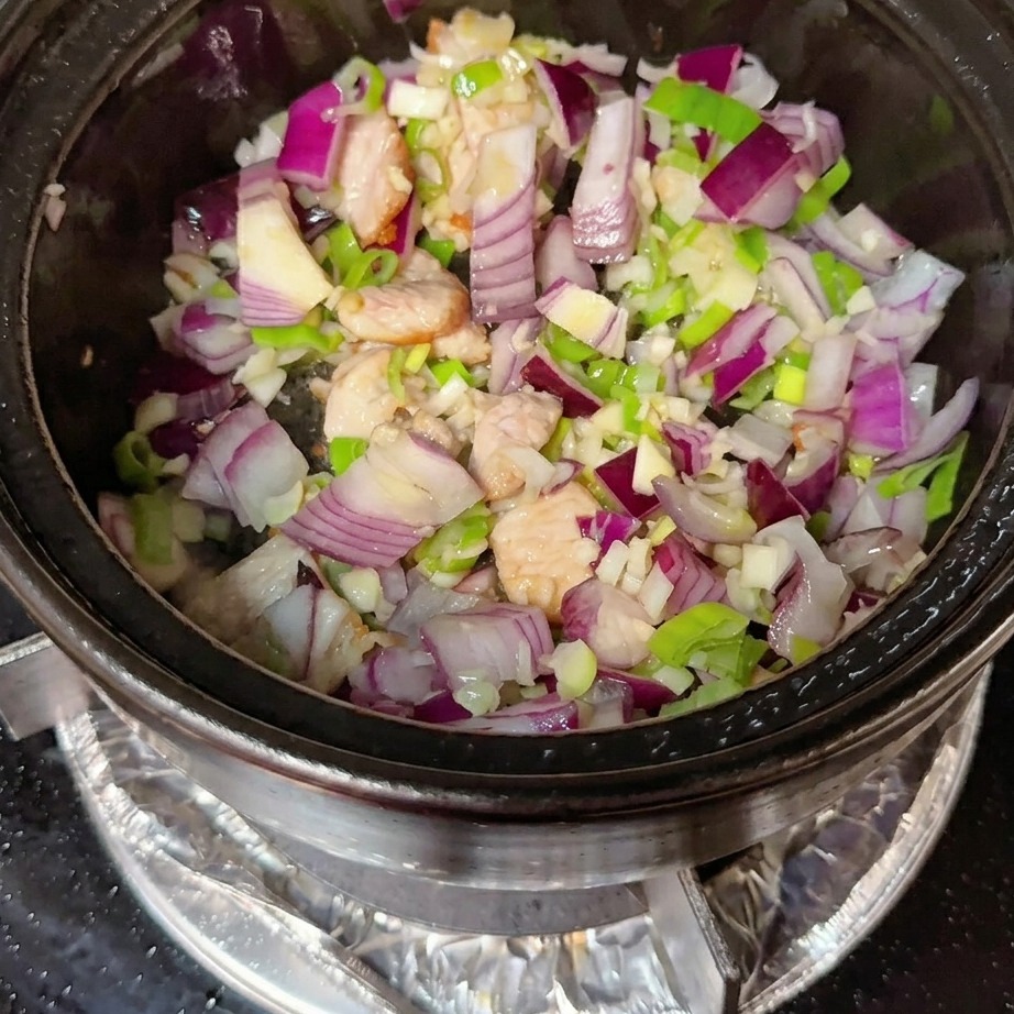 Pâte de piment coréenne et poudre de piment rouge incorporées au mélange de porc et daromates.