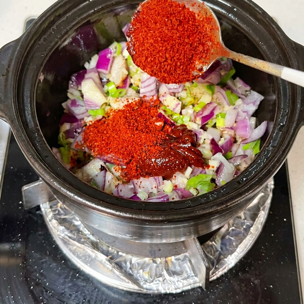 Sauce soja et kimchi incorporés dans un pot avec des oignons en dés et des aromates.