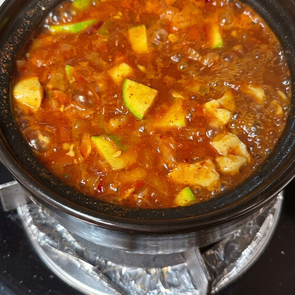 Fines tranches de bœuf et œufs crus ajoutés à la soupe frémissante.