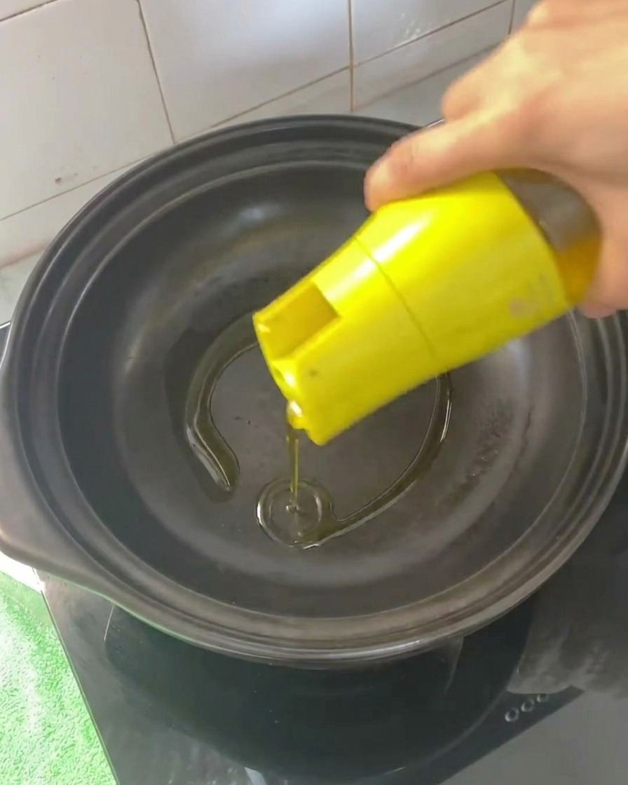 Huile de cuisson versée dans une cocotte vide préchauffée.