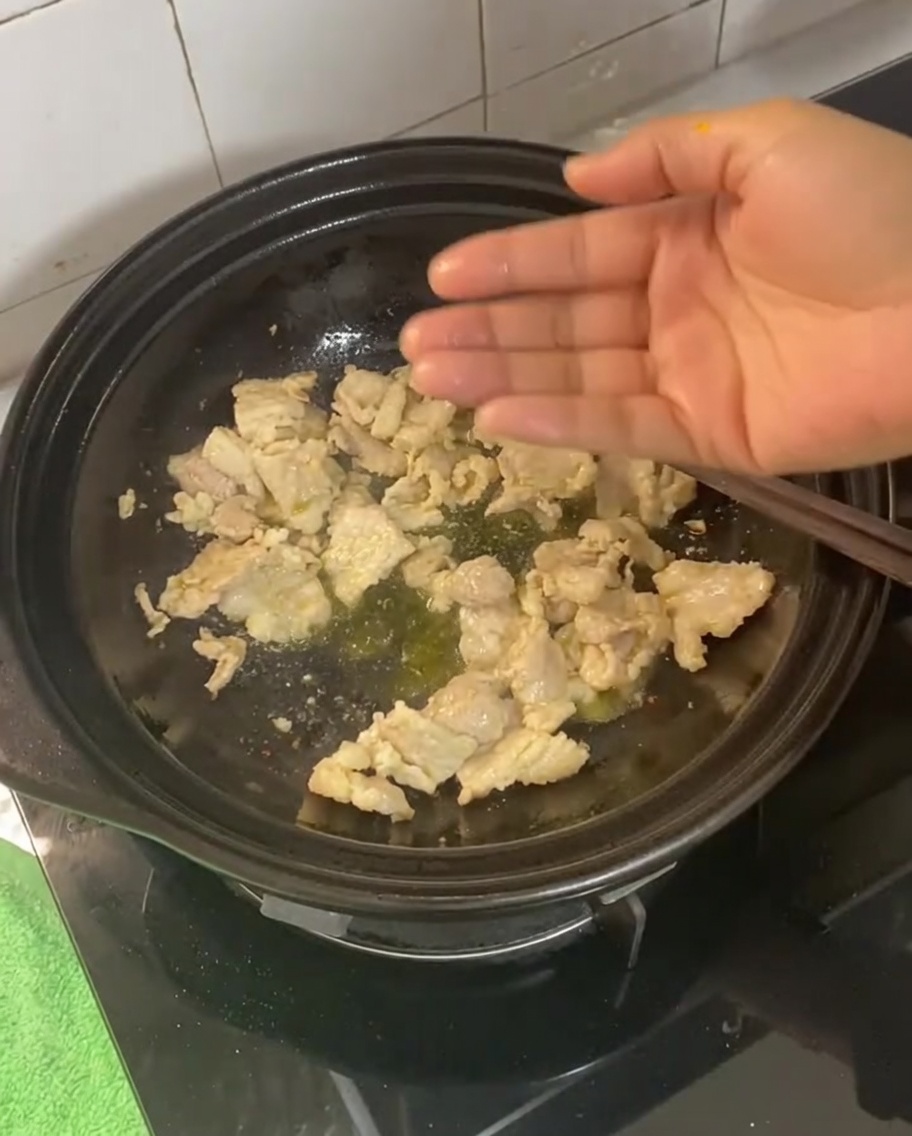 Gingembre, ail, oignons verts et piments séchés incorporés au porc cuit.