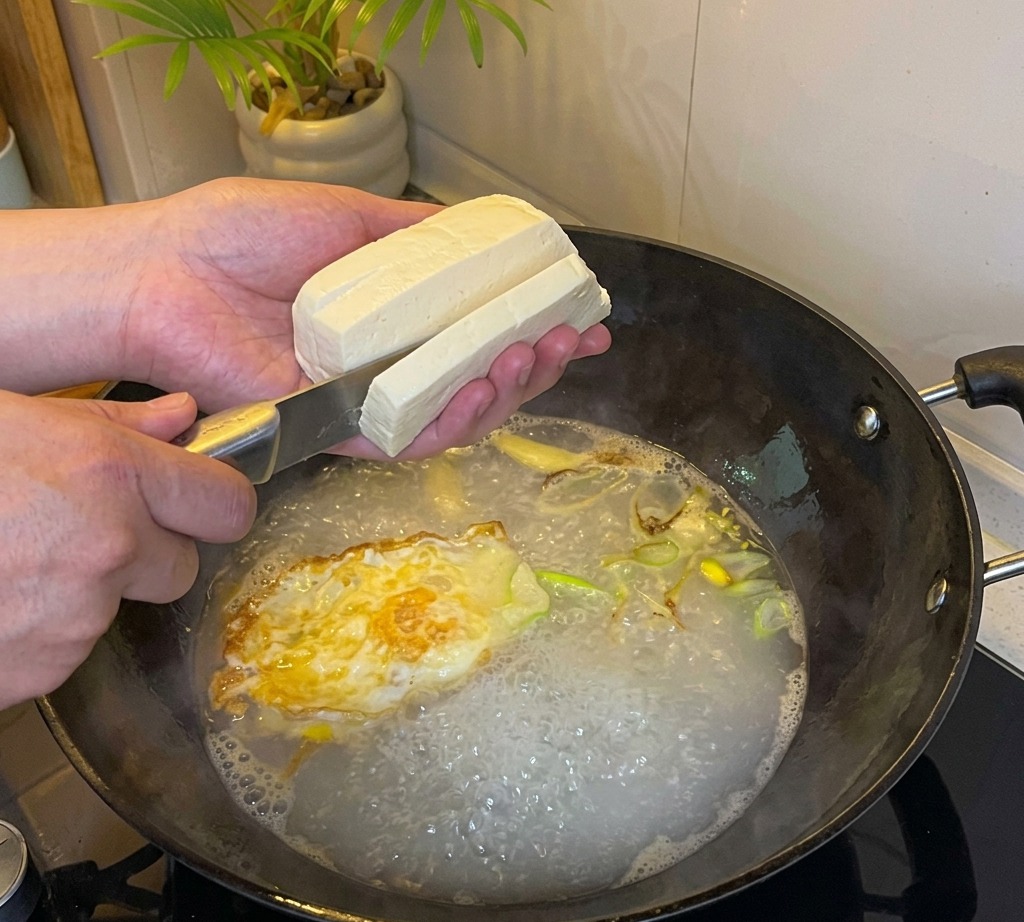Tofu coupé en cubes directement dans le bouillon bouillant.