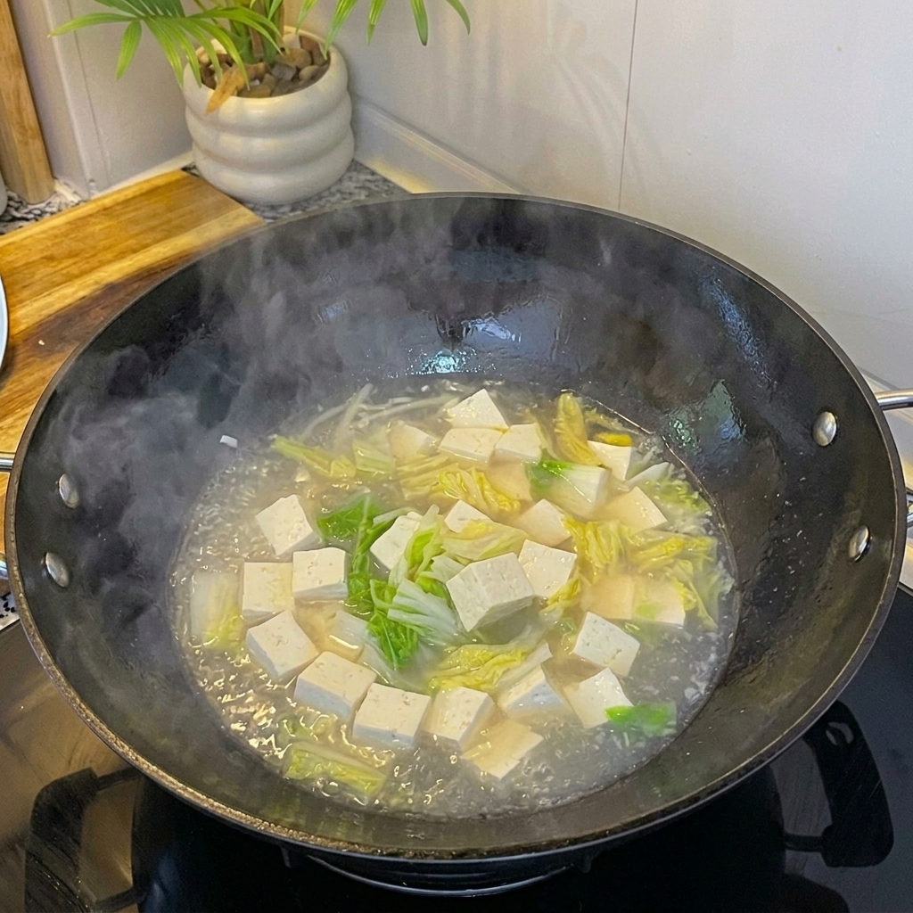 Palourdes blanches fraîches ajoutées à la soupe frémissante avec le tofu et lœuf.