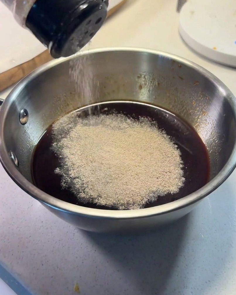 Ingrédients de la sauce combinés dans un petit bol en métal avec du poivre noir saupoudré sur le dessus.
