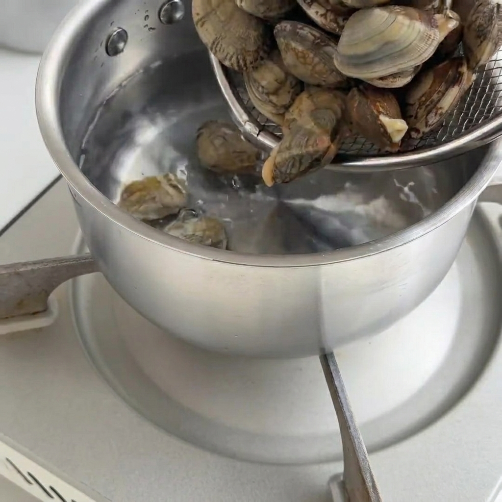 Palourdes fraîches dans une casserole deau bouillante.