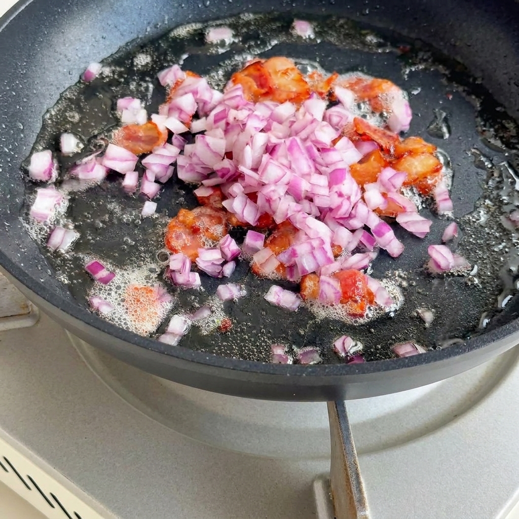 Oignons, céleri et pommes de terre sautés dans le gras de bacon.