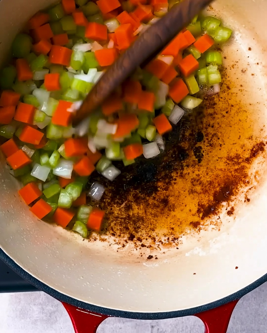 Oignons, céleri et carottes sautant dans une casserole avec le gras de lard réservé.