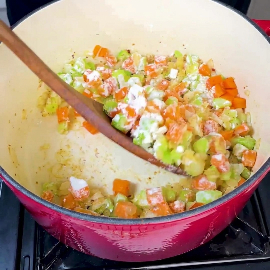 Farine ajoutée à la casserole de légumes sautés et mélangée soigneusement.