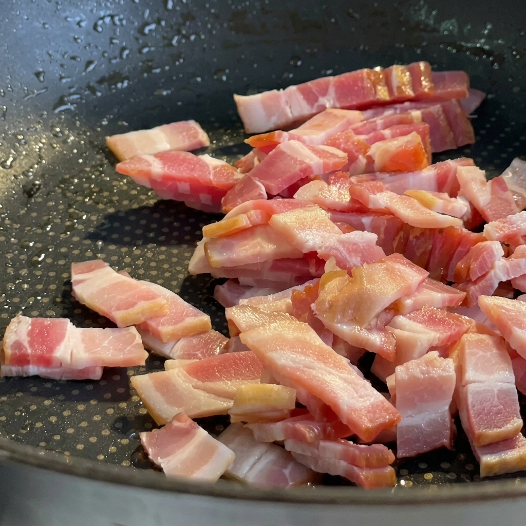 Morceaux de pancetta frits dans une poêle jusquà ce quils soient dorés et croustillants.
