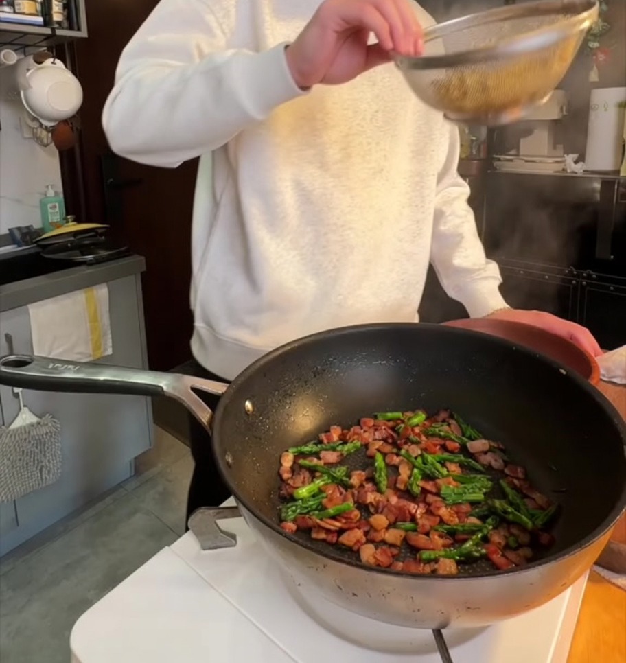 Pennes bouillies ajoutées dans la poêle avec la pancetta croustillante et les pointes dasperges sautées.