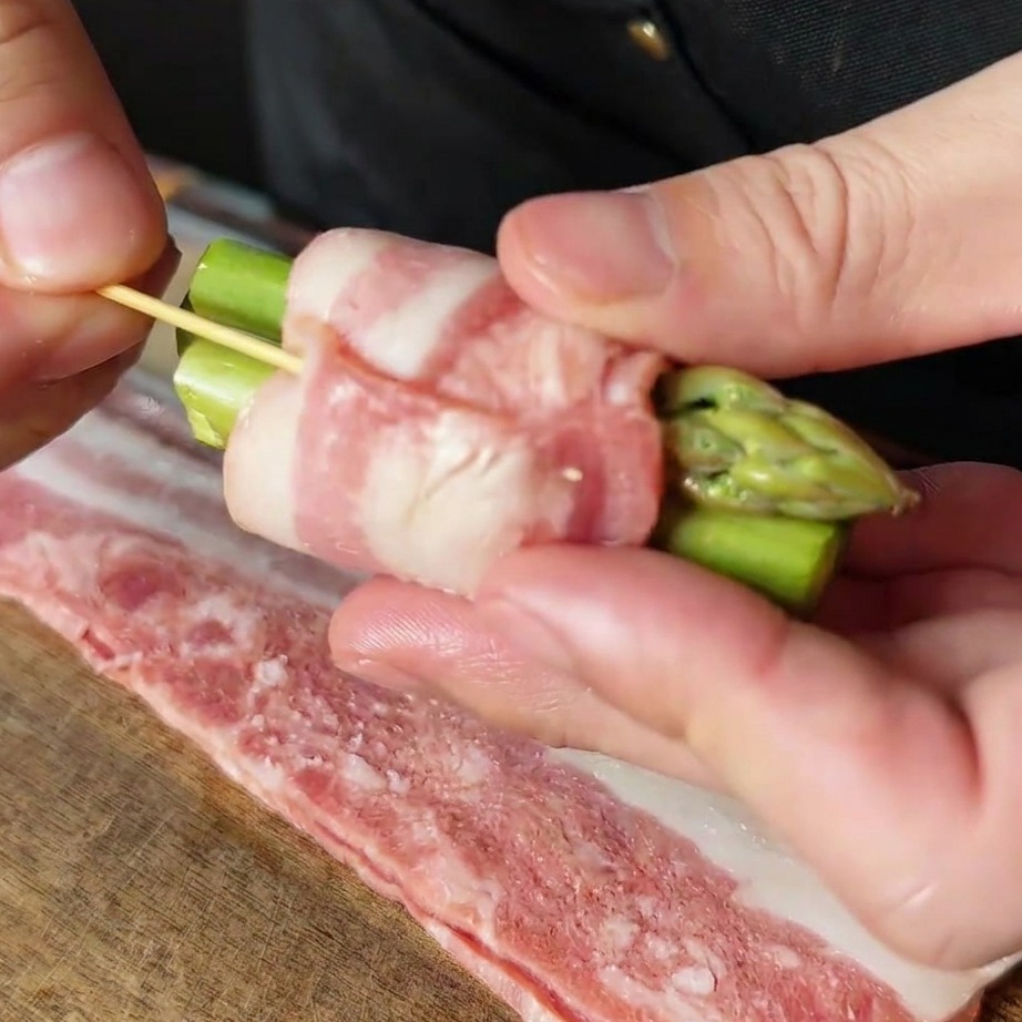 Un roulé dasperges au bacon sécurisé avec un petit cure-dent en bois.