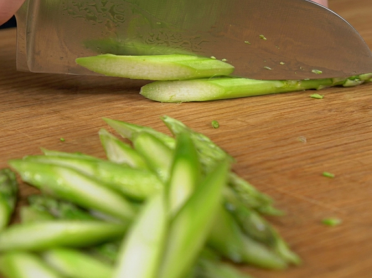 Des petits pois frais tombant dans une casserole deau bouillante frémissante.