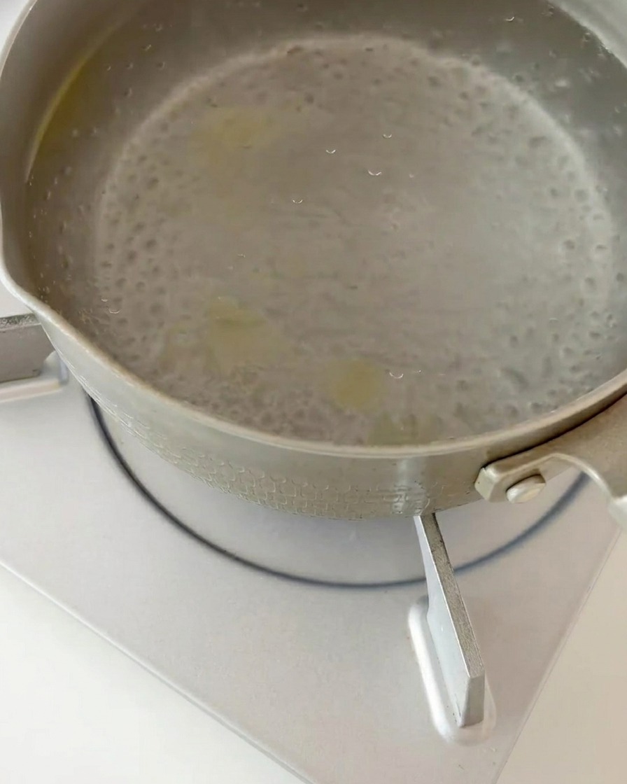 Fusilli cuits égouttés de leau bouillante dans une passoire de cuisine.