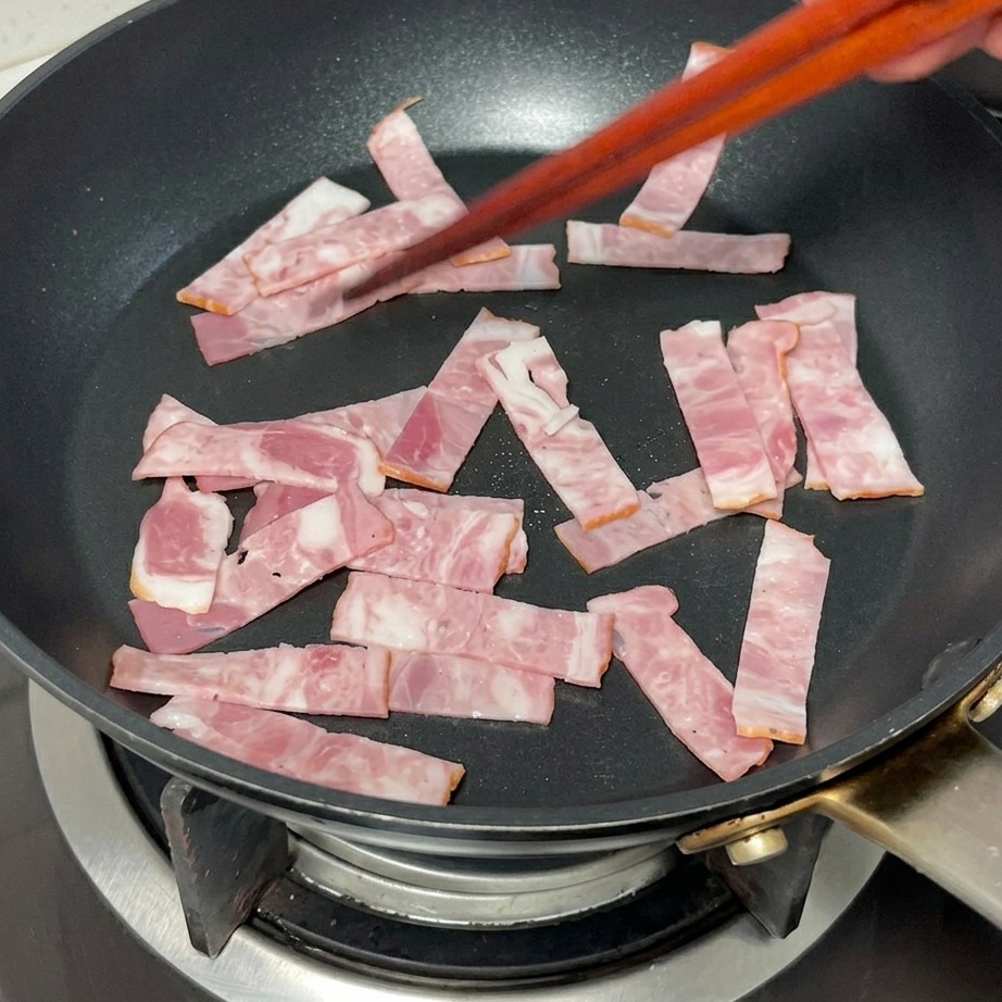 Tranches de bacon grillant dans une poêle jusquà obtenir une couleur dorée.
