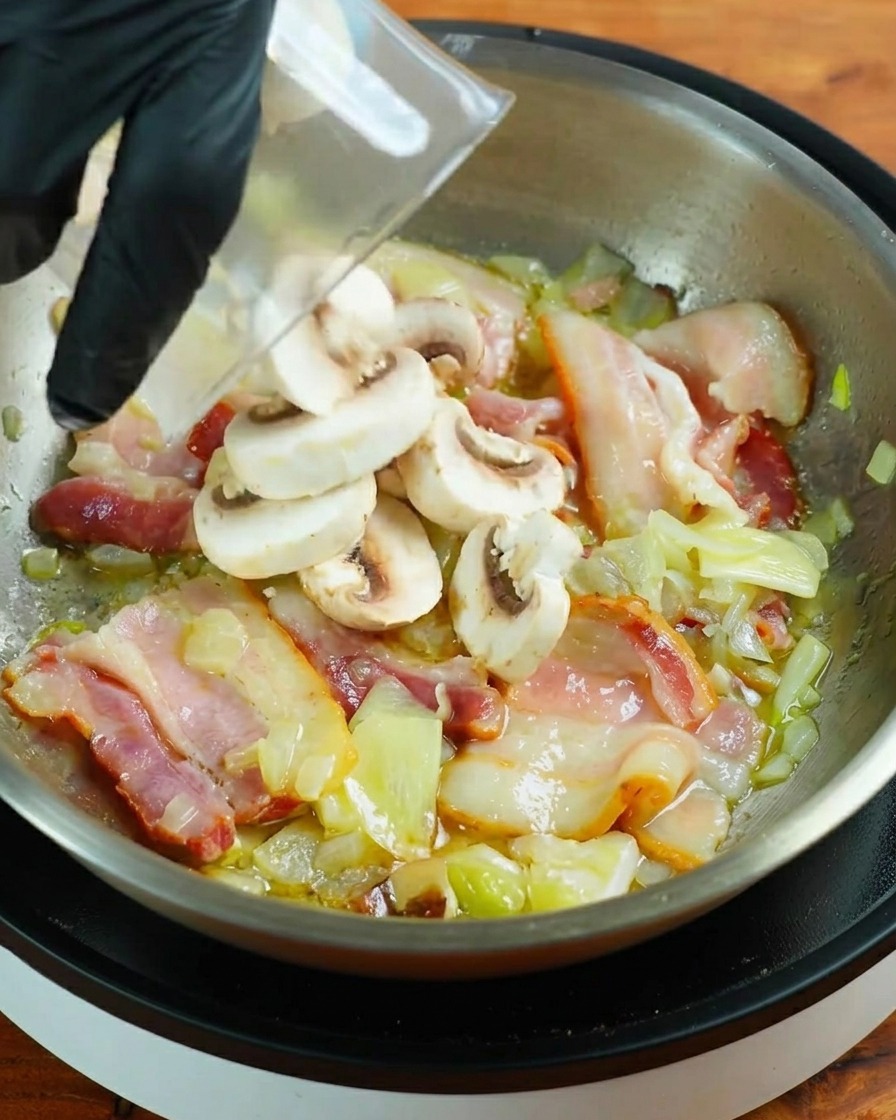 Tranches de champignons de Paris frais versées dans une poêle avec le bacon en train de frire.