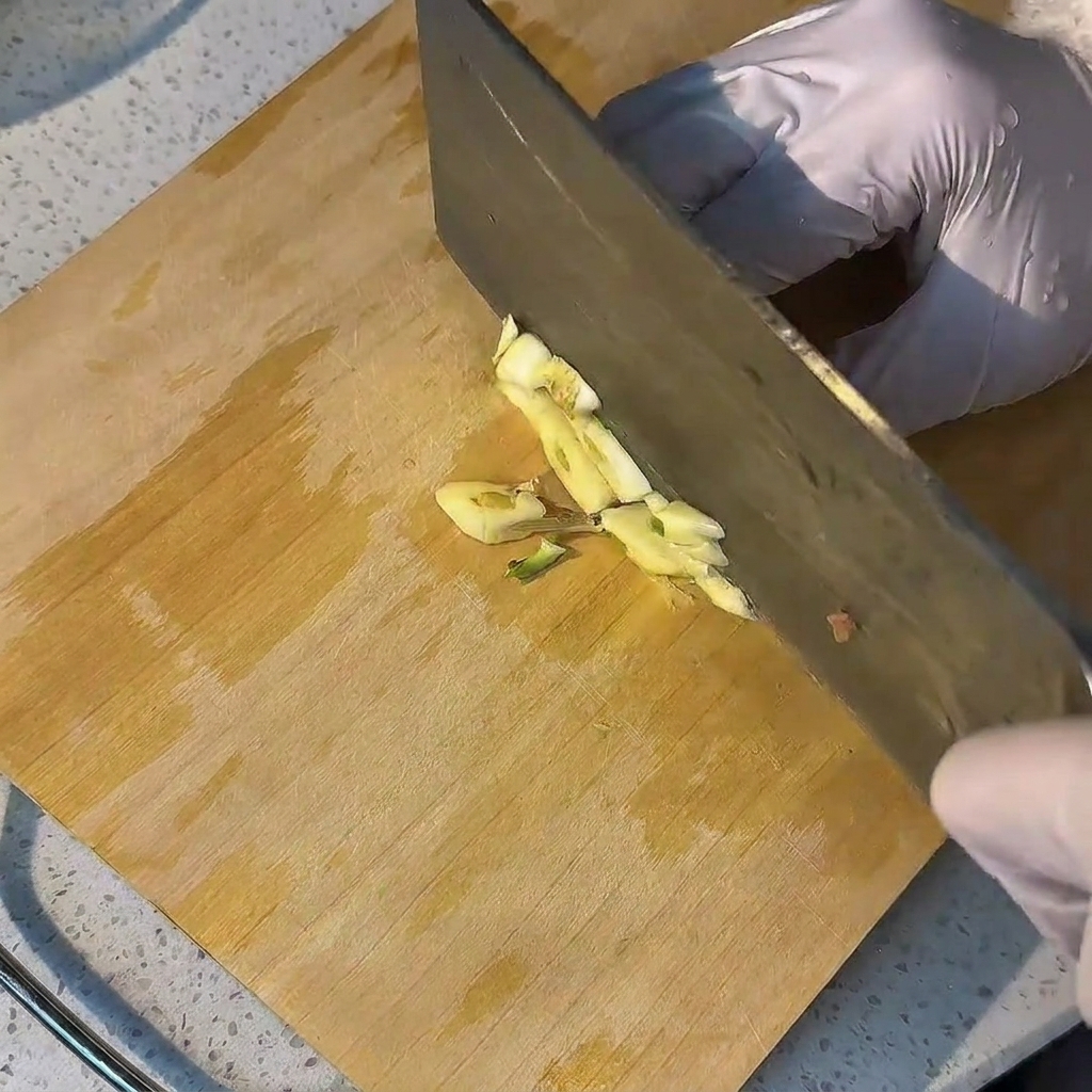 Gousses dail frais hachées sur une planche à découper en bois.