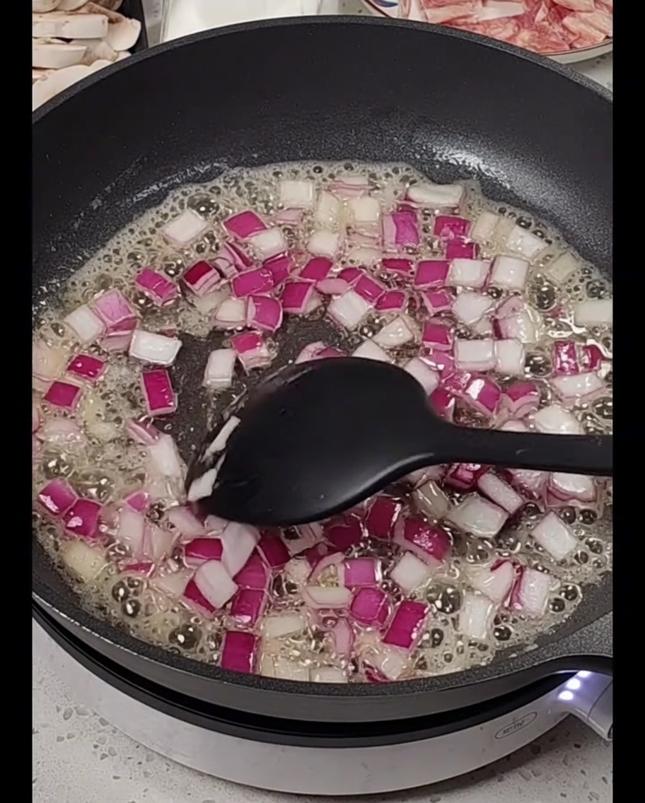Oignons rouges en dés cuisant dans du beurre fondu.