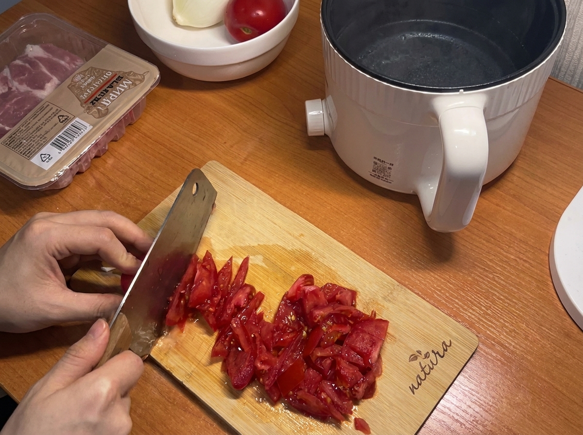 Des tomates rouges fraîches coupées en petits morceaux sur une planche à découper en bois.