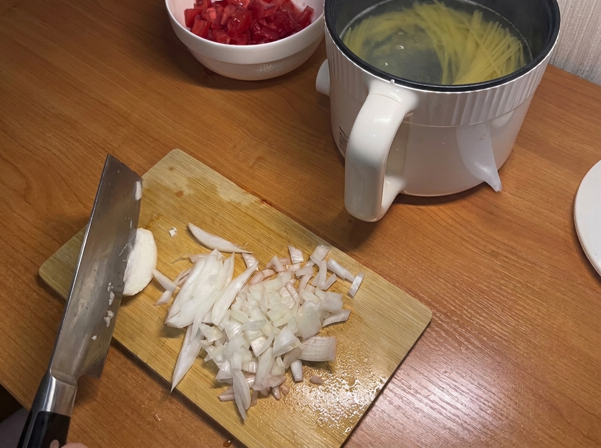 Un oignon blanc coupé en petits dés sur une planche à découper en bois.