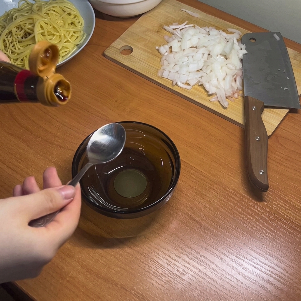 Des condiments liquides foncés, dont les sauces soja et dhuître, mélangés dans un petit bol en verre.
