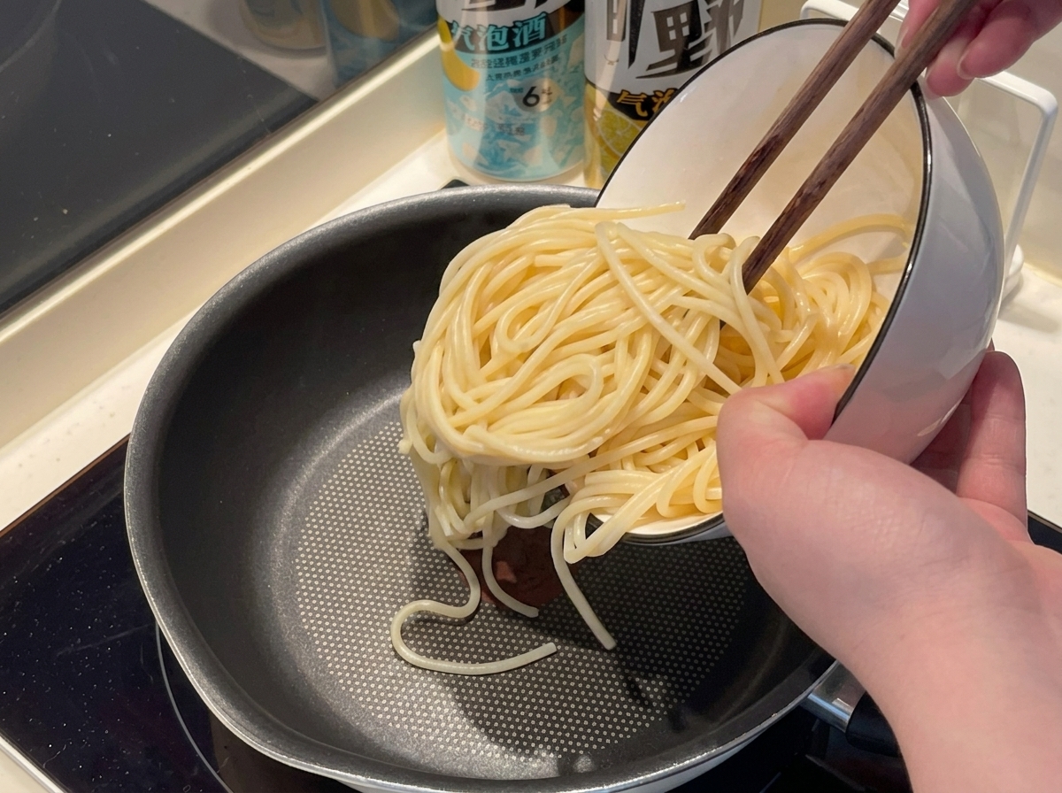 Spaghettis plongés dans une marmite deau bouillante.