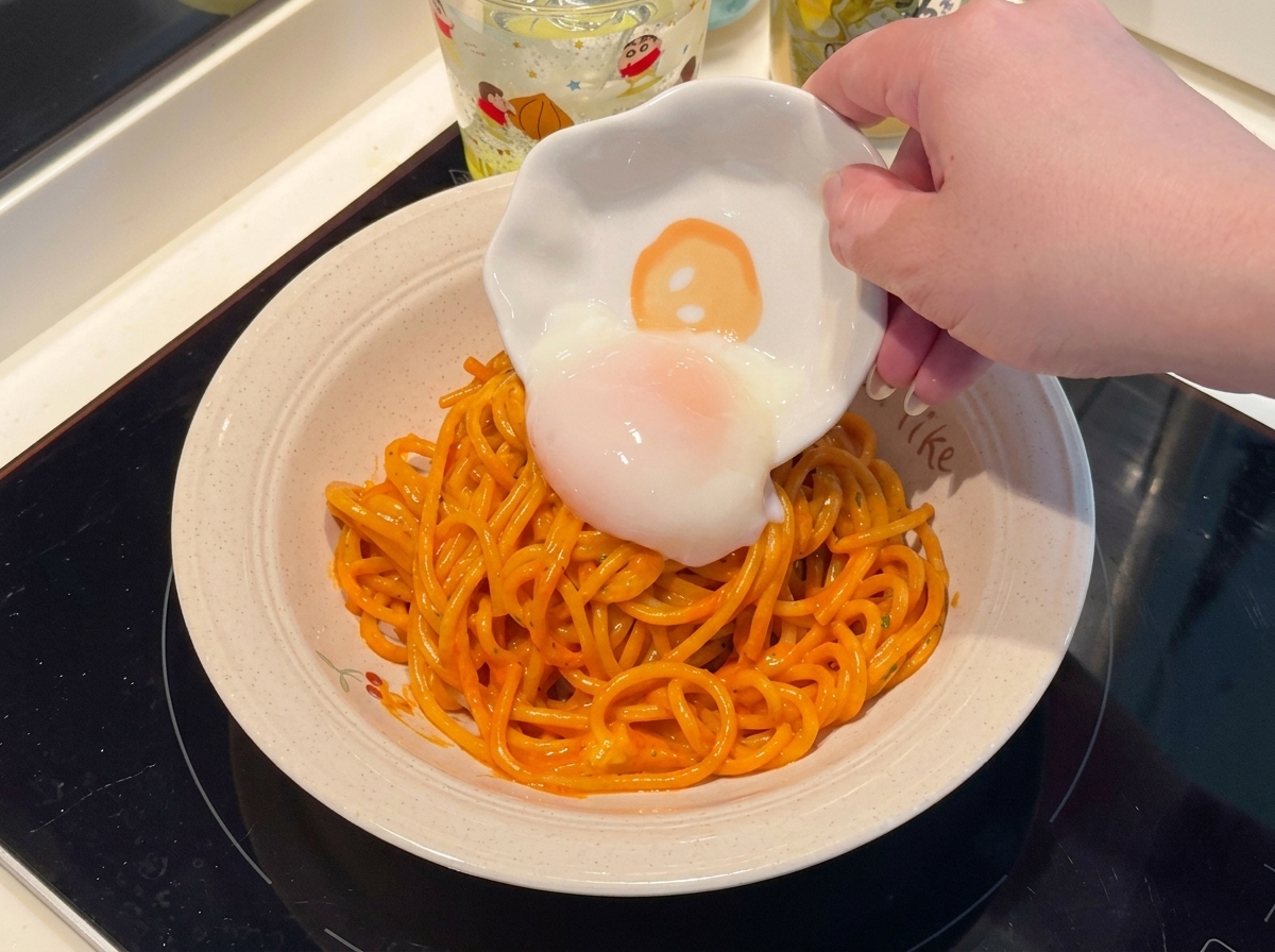 Un œuf mollet posé délicatement sur lassiette de spaghettis.