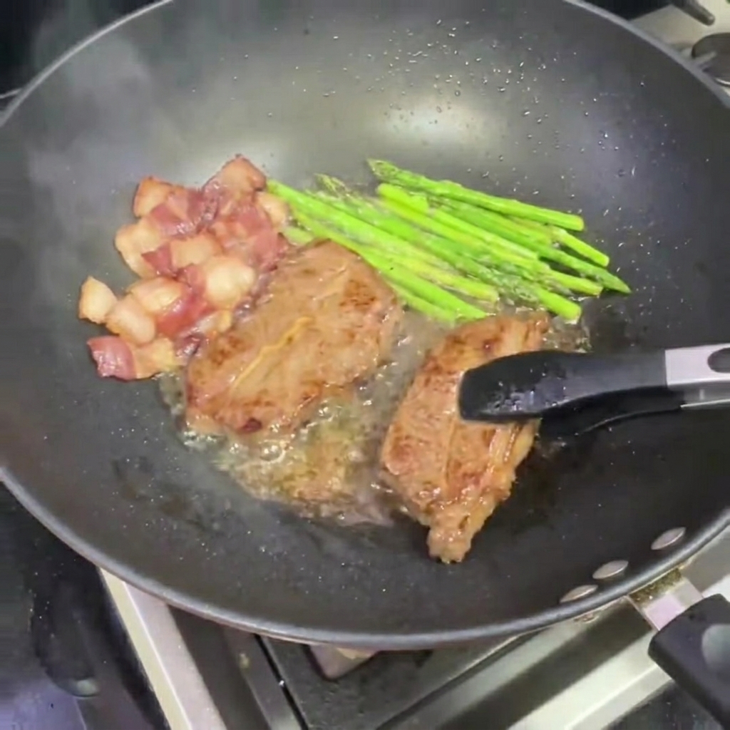 Une pince retirant un morceau de steak saisi du wok.