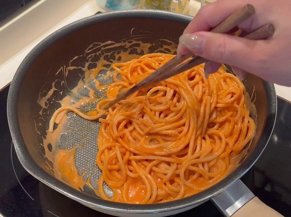 De la chapelure étant saupoudrée soigneusement autour du périmètre de la pâte de la pizza assemblée.