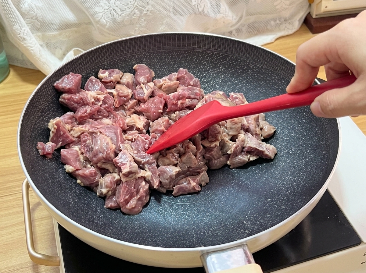 Les cubes de bœuf dorant dans la poêle avec une belle croûte caramélisée.