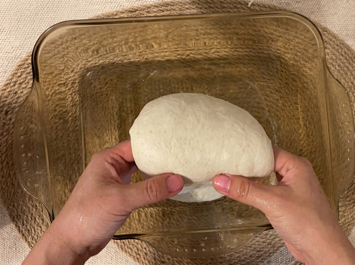 Pâte soulevée par le centre dans un plat en verre.