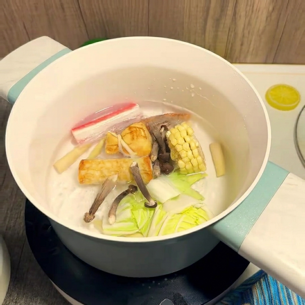 Ingrédients colorés comme le maïs et les crevettes cuisant dans une casserole deau bouillante.