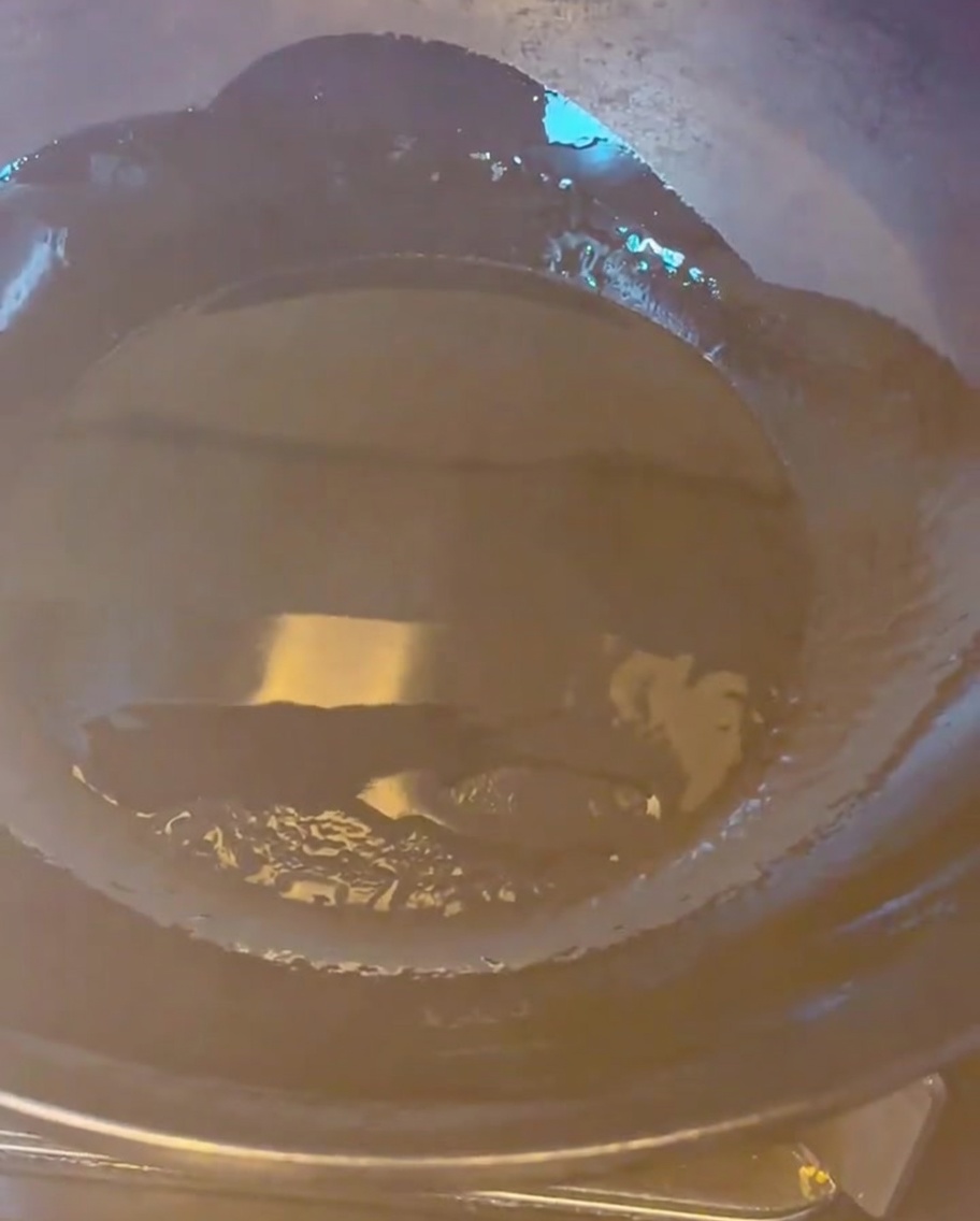 Morceaux de poitrine de porc dorant dans un wok chaud avec de lhuile.